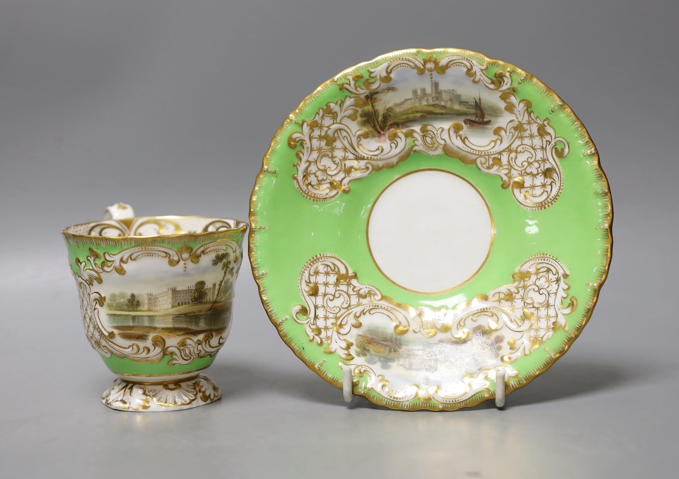 Copeland and Garrett fine topographical pedestal coffee cup and saucer with green ground painted with Sion House on the cup and Lincoln and Malsbury Abbey on the saucer c. 1840